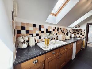 una cucina con un lavello e un piano di lavoro di Hallagenna Cottages a Bodmin Altre 101 foto