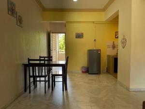 comedor con mesa, sillas y nevera en Private,Glory Beach Resort port dickson-negeri sembilan, en Port Dickson