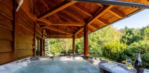 a hot tub in a house with a wooden ceiling at Grande Vendégház in Tata