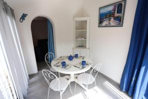 a dining room with a white table and chairs at Argeles sur Mer jolie maison avec terrasse et piscine in Plage dʼArgelès +4 photos