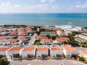 an aerial view of a city with houses and the ocean at Ericeira Panoramic Sea View Apartments in Ericeira
