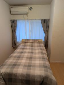 a bedroom with a bed with a checkered blanket at Colin Home Intimo Amigo in Tokyo +13 photos