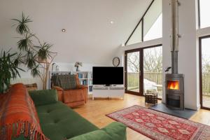 a living room with a couch and a tv and a fireplace at 6 The Links in Penzance
