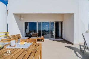 a patio with a table and chairs on a balcony at Ericeira Panoramic Sea View Apartments in Ericeira