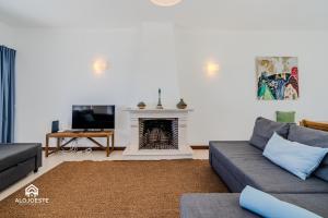 a living room with a couch and a fireplace at Ericeira Panoramic Sea View Apartments in Ericeira