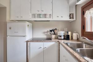 a kitchen with white cabinets and a sink at Cottage Vittoria in Marazzino