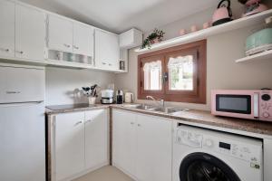 a kitchen with white cabinets and a sink and a microwave at Cottage Vittoria in Marazzino +23 photos