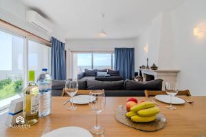 a living room with a table with fruit and wine glasses at Ericeira Panoramic Sea View Apartments in Ericeira