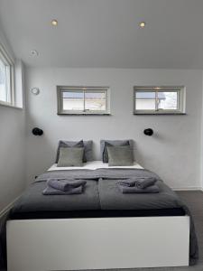 a bedroom with a large bed with two windows at Lilla huset på Norregårda in Hammenhög