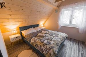 a bedroom with a bed with a wooden ceiling at Słoneczna Wetlina - Apartament 3 in Wetlina +8 photos