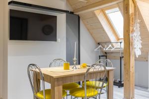 a dining room with a wooden table and chairs at Słoneczna Wetlina - Apartament 3 in Wetlina
