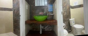 a bathroom with a green sink and a toilet at Hosteria Cattleya in San Andrés