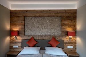 Un dormitorio con una cama con dos almohadas rojas. en Triad Gästehaus DZ, en Krumbach Markt