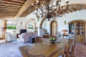 Una gran sala de estar con una mesa y una lámpara de araña. en Pool Villa Volterra by Villaflair, en Volterra