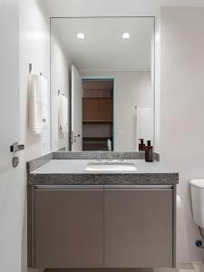 a bathroom with a sink and a large mirror at Glória Del Art - Vista, Estilo e Praticidade no Centro do Rio in Rio de Janeiro
