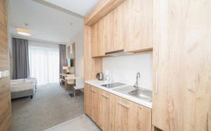una cucina con mobili in legno e un lavello di Apart Czarna Góra Resort Rowery, Spa, Narty, Góry a Sienna Altre 30 foto
