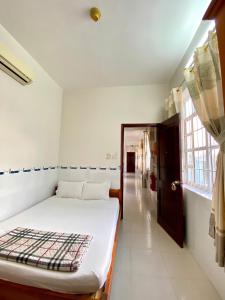 Una habitación blanca con una cama y una ventana en Kim Thành Phát guest house, en Phu Quoc