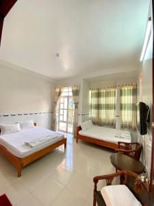 Un dormitorio con dos camas y una ventana. en Kim Thành Phát guest house, en Phu Quoc