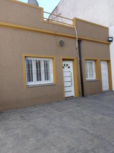 un edificio con una puerta blanca y dos ventanas en Hospedaje DUDOMU, en Buenos Aires
