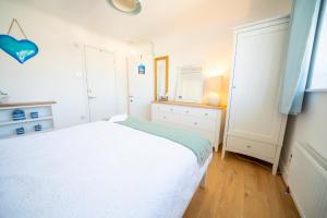 ein Schlafzimmer mit einem weißen Bett und einem Spiegel in der Unterkunft Trethvor House FREE PARKING, Ensuite Double Quiet residential area in Padstow + 8 Fotos