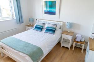 ein Schlafzimmer mit einem weißen Bett mit blauen Kissen in der Unterkunft Trethvor House FREE PARKING, Ensuite Double Quiet residential area in Padstow