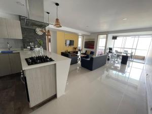 a large kitchen and living room with a stove top at Amplio apartamento con vista campestre in Sabaneta