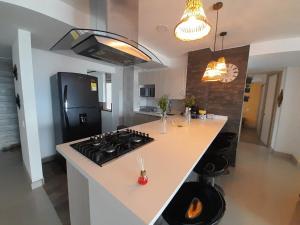 a kitchen with a stove and a counter top at Amplio apartamento con vista campestre in Sabaneta +12 photos