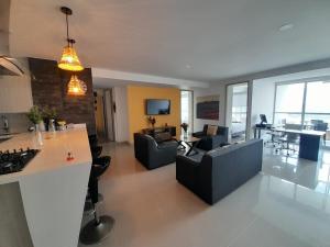 a kitchen and living room with couches and a table at Amplio apartamento con vista campestre in Sabaneta