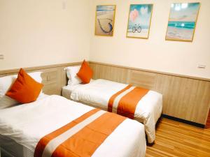 a hotel room with two beds and pictures on the wall at 金門民宿-藍月金門民宿 親子-團體-唱歌-可包棟 in An-ch'ien