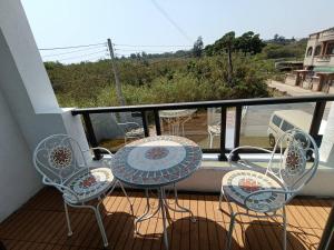 a balcony with a table and chairs on a balcony at 藍月金門民宿 in An-ch'ien
