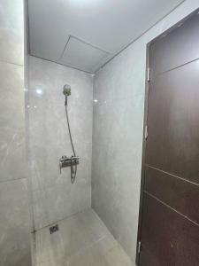 a bathroom with a shower with a shower door at Cozy Studio Apartement South Surabaya in Surabaya +13 photos