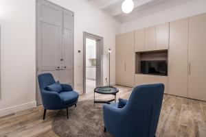 a living room with two chairs and a table at Old Theatre Suites - Vulcano in Valletta