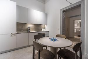 a kitchen with a table and chairs in a room at Old Theatre Suites - Vulcano in Valletta