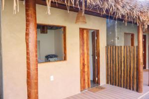 a house with a thatch roof and a door at Euodoo Suíte in São Miguel dos Milagres