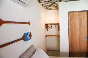 Cette chambre comprend un lit et une porte en bois. dans l'établissement Euodoo Suíte, à São Miguel dos Milagres
