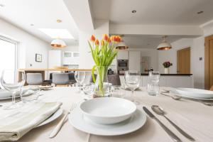 a white table with a vase of flowers on it at Woodlands in Charlbury
