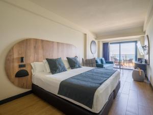 a bedroom with a large bed and a living room at Sercotel Playa Canteras in Las Palmas de Gran Canaria