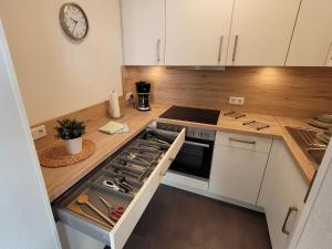 a kitchen with white cabinets and a clock on the wall at Schmallenberger Auszeit in Schmallenberg
