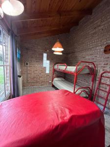 a red bed in a room with a brick wall at Cabañas Buena Vista in Sierra de la Ventana +45 photos