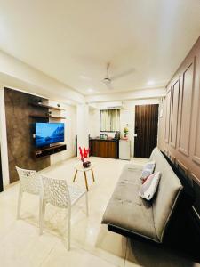 安君纳Spacious 1bhk in Vagator with Pool and near beach的带沙发、椅子和电视的客厅