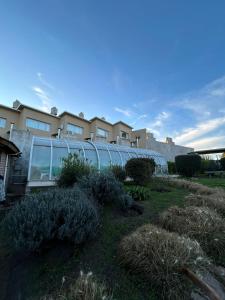 a building with a glass wall in a yard at Cabañas Buena Vista in Sierra de la Ventana