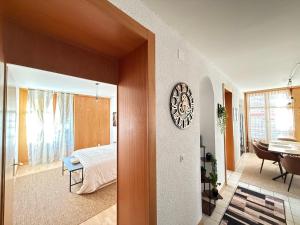 a bedroom with a bed and a clock on a wall at Votre oasis au cœur de Lausanne in Lausanne