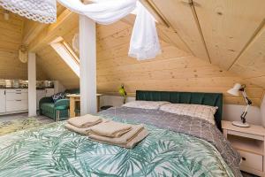 a bedroom with a bed in a wooden attic at Słoneczna Wetlina Apartament 4 Typu Studio in Wetlina