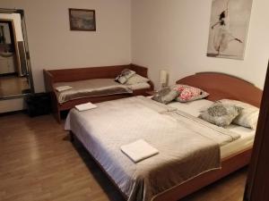 a bedroom with two beds and a couch at Rooms Kapelj in Postojna