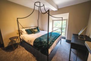 een slaapkamer met een hemelbed en een bureau bij The Richmond Suite in Marske