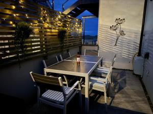 a table and chairs on a balcony with a view of the ocean at Crown Cottage in Tenby