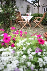 a table and two chairs in a garden with flowers at Hotel Elysee in Seligenstadt