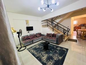 a living room with a couch and a staircase at Marseilia beach2 in Al Ḩammām