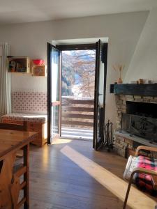 a living room with a door open to a fireplace at Casa Giuseppina in Temù