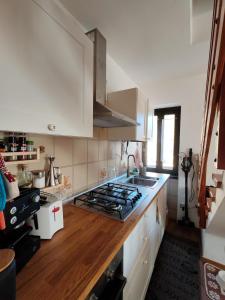 a kitchen with white cabinets and a stove top oven at Casa Giuseppina in Temù